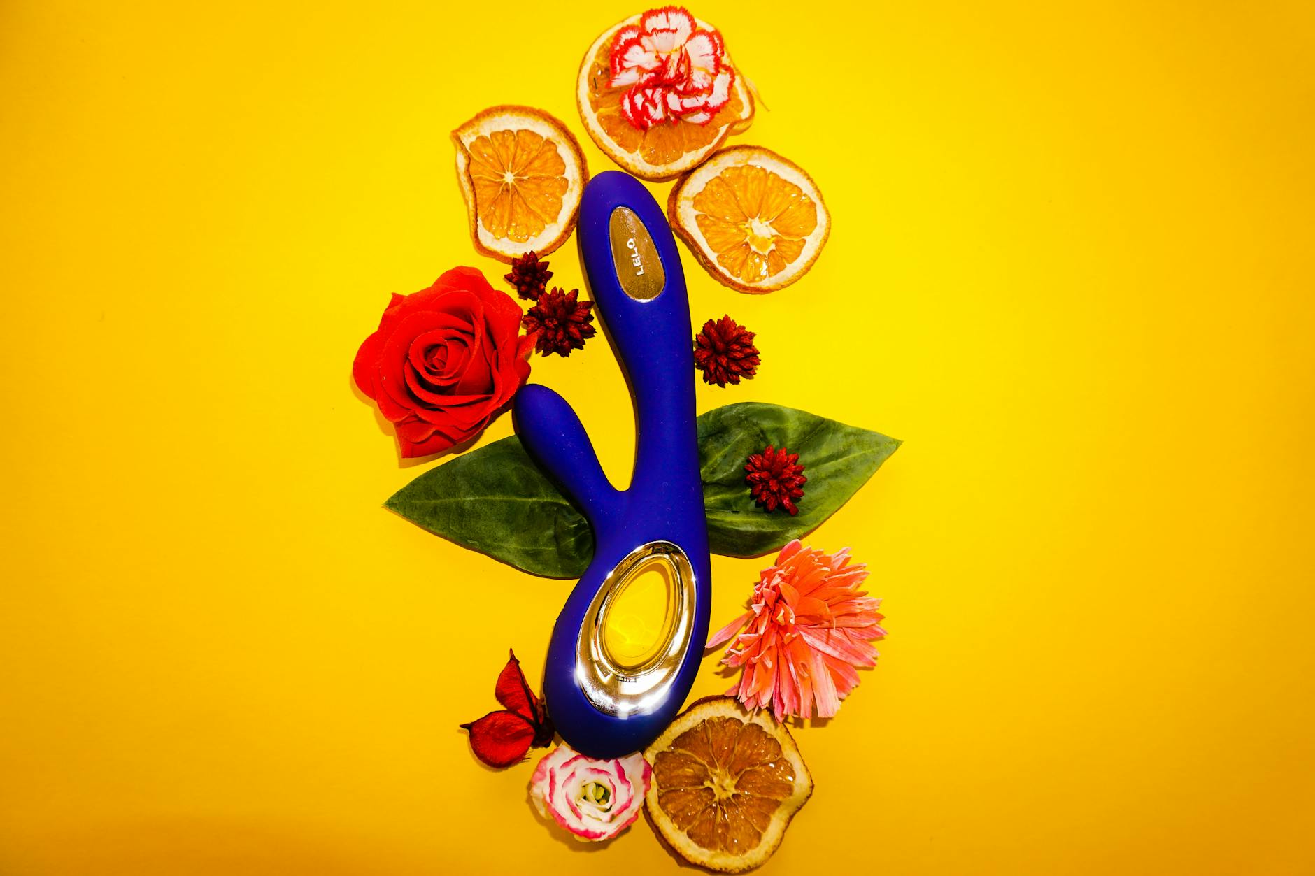 A blue lemon vibrator surrounded by fresh yellow lemons on a bright yellow background